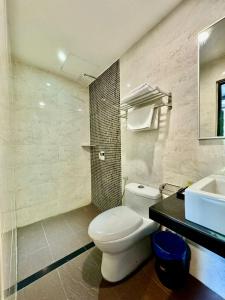 a bathroom with a white toilet and a sink at Chariton Hotel Nusa Bestari in Johor Bahru