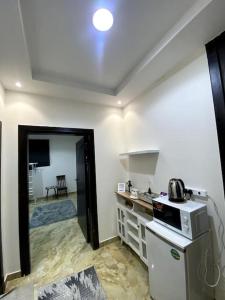 a kitchen with a sink and a microwave at استديو في حي النهضة - دخول ذكي ٤أ in Buraydah