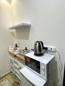 a microwave oven with a tea kettle on top of it at استديو في حي النهضة - دخول ذكي ٤أ in Buraydah