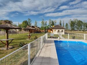 a swimming pool with a white fence and a yard at Finca el gallego in Junín
