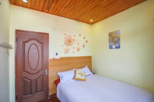 a bedroom with a bed and a wooden door at Villa Hang Nga 2 in Da Lat