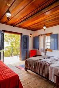 a bedroom with a bed and a large window at Pouso Du Ferreiro in Tiradentes