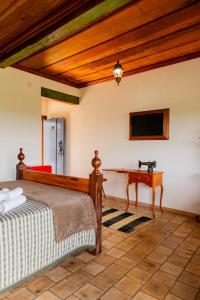 a bedroom with a bed and a desk at Pouso Du Ferreiro in Tiradentes