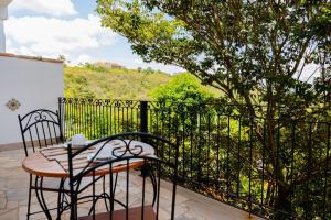 a patio with a table and chairs on a balcony at Pouso Du Ferreiro in Tiradentes