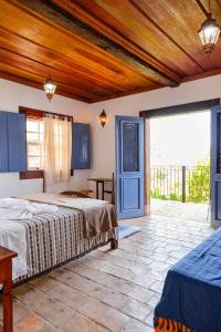 a bedroom with a bed and a large window at Pouso Du Ferreiro in Tiradentes