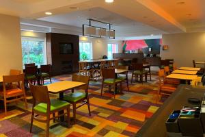 a restaurant with tables and chairs and a bar at Fairfield Inn Concord in Concord