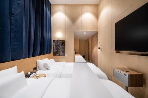 a hotel room with two beds and a flat screen tv at The Hyoo Sik ANNK Hong Dae Branch in Seoul
