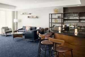 um bar num quarto com um sofá e cadeiras em Courtyard by Marriott Concord em Concord