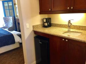 een hotelkamer met een wastafel en een slaapkamer bij Resort King Studio with Private Balcony 064622 in La Quinta