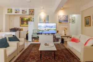 sala de estar con 2 sofás y TV de pantalla plana en Hospedaria Conceitual en Florianópolis