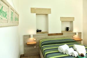 a bedroom with a bed with two windows at Manipinta B&B in Corigliano dʼOtranto