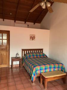 1 dormitorio con cama, mesa y ventana en La Casa de Dona Irma Townhouse, en Copan Ruinas