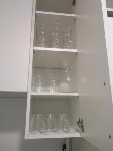 a cupboard filled with clear glass bowls and glasses at Studio cosy tout confort proche aéroport et Paris in Choisy-le-Roi