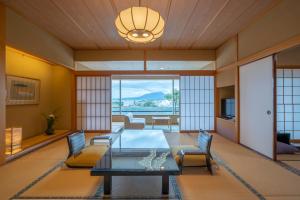 sala de estar con mesa de cristal y sillas en Kaike Tsuruya en Yonago