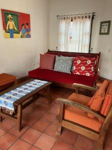 salon z czerwoną kanapą i stołami w obiekcie La Casa de Dona Irma Townhouse w mieście Copán