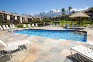 a swimming pool with lounge chairs and an umbrella at Hale Kamaole 158 in Wailea