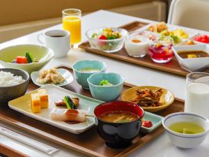 a table topped with plates of food and bowls of food at Manza Kogen Hotel in Tsumagoi