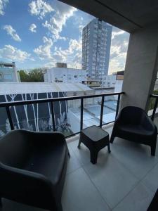 2 sillas y un taburete en un balcón en Departamento Nuñez en Buenos Aires