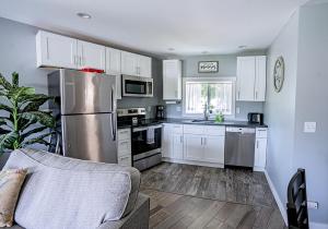 eine Küche mit weißen Schränken und einem Kühlschrank aus Edelstahl in der Unterkunft Peak Haven: 2BR Mountain View in Kellogg