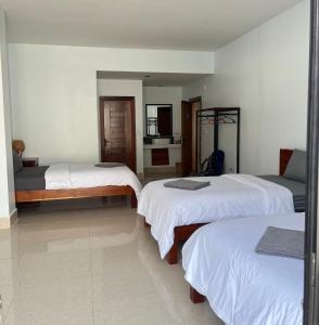 a hotel room with three beds and a television at Sorya Guesthouse & Dolphin Tours in Kratie