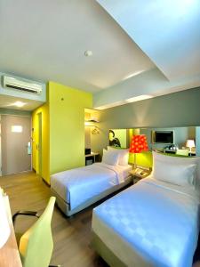 a hotel room with two beds and a desk at Khas Gresik in Gresik