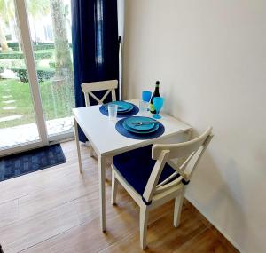 a white table with two chairs and a blue plate at Útulné kondominium s vybavením 1 minutu od pláže in Cabarete