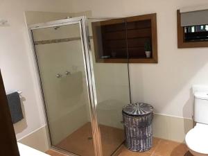 a glass shower in a bathroom with a trash can at Oasis, in leafy Whitfield. in Edge Hill +21 photos