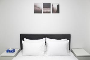 Cama blanca con almohadas blancas y cabecero negro en Suite Apartment #17 By Hashdera Eilat, en Eilat