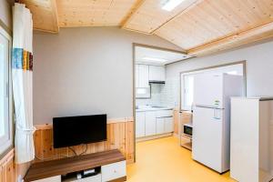 Il comprend une cuisine équipée d'une télévision et d'un réfrigérateur. dans l'établissement Garden Pension, à Damyang