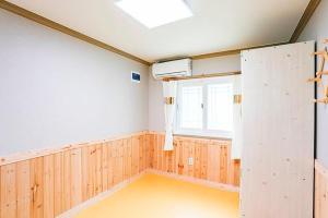 une chambre vide avec une chambre dotée d'une fenêtre dans l'établissement Garden Pension, à Damyang
