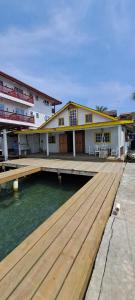 a building with a wooden dock next to the water at Paraíso frente al Mar. in Carenero