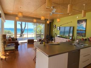 a kitchen with a view of the ocean at Bliss on the Beach - Whangapoua in Whangapoua