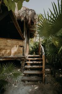 a staircase leading to a house with a straw roof at Sacred Hideaways in Tulum