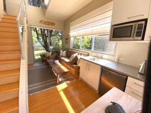 a tiny house with a kitchen and a living room at Bliss on the Beach - Whangapoua in Whangapoua