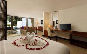 a hotel room with a bed with two swansitures at Lv8 Resort Hotel in Canggu