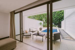 a living room with sliding glass doors leading to a pool at Lv8 Resort Hotel in Canggu