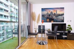 uma sala de jantar com uma mesa com cadeiras e uma televisão em Cobalt Point 2 em Londres