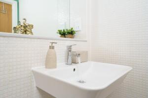 um banheiro branco com uma pia e um espelho em Cobalt Point 2 em Londres mais 16 fotografias