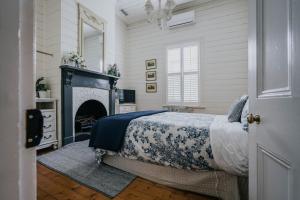 a bedroom with a bed and a fireplace at Lake Daylesford Country House in Daylesford