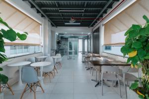 a restaurant with tables and chairs and plants at KHÁCH SẠN 101 CẦN THƠ in Can Tho