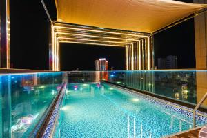 a swimming pool on top of a building at night at KHÁCH SẠN 101 CẦN THƠ in Can Tho
