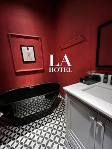 uma casa de banho com uma banheira preta e uma parede vermelha em La Hotel em Trung An