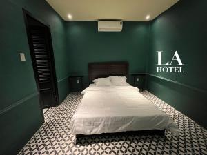 ein Schlafzimmer mit einem großen Bett in einer grünen Wand in der Unterkunft La Hotel in Trung An