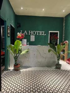 um hotel com dois vasos de plantas e uma parede verde em La Hotel em Trung An