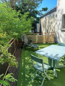 eine Terrasse mit einem Tisch und Stühlen auf dem Rasen in der Unterkunft Appartement d'une chambre avec terrasse et wifi a Brives Charensac in Brives-Charensac