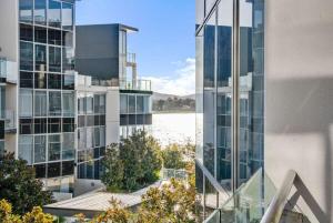 a building with a view of a body of water at Canberra Lakefront 2-Bed with Pool, Gym & Parking in Kingston 