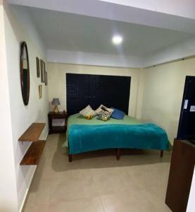 ein Schlafzimmer mit einem grünen Bett in einem Zimmer in der Unterkunft Departamento feliz in Sucre
