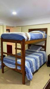 two bunk beds in a room with blue sheets at Departamento feliz in Sucre