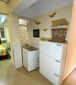 Zimmer mit Kühlschrank und Vögeln an der Wand in der Unterkunft Departamento feliz in Sucre