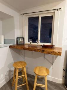 a kitchen counter with two stools and a window at Cabin in the woods @ Cultus Lake in Chilliwack